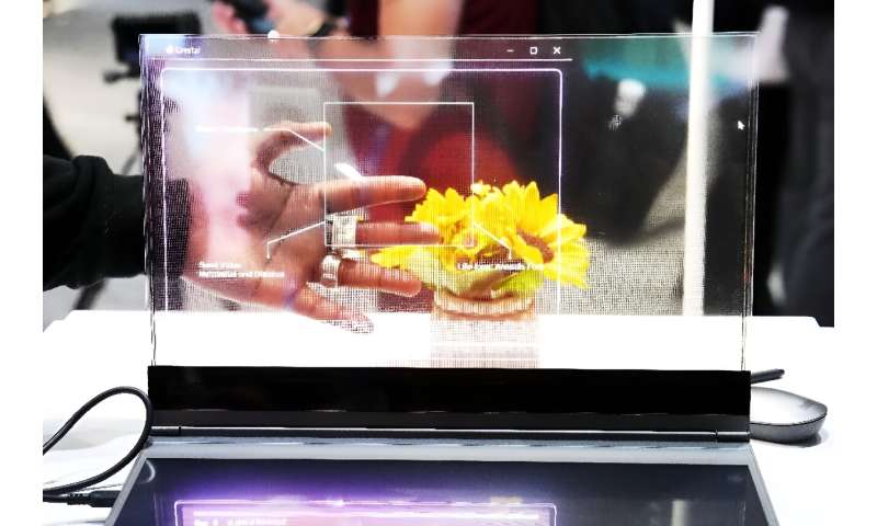 A visitor tests the transparent display of new Lenovo ThinkBook laptop on the first day of the Mobile World Congress (MWC) in Barcelona